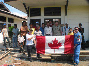Colonel Paul Morneault of the Canadian Defense Attaché Office in Jakarta poses with CMAT  volunteers in front of clinic at Drien Rampak. (January, 2005).