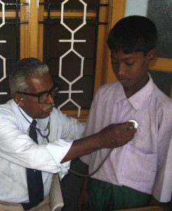 A young boy gets a checkup from a doctor in Sri Lanka.