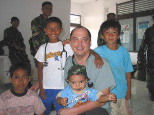 CMAT physician Dr. Darryl Leiski of Vancouver, B.C. poses with child survivors of the Tsunami in Meuloboh, Indonesia. The Indonesian Military (background) provided security for CMAT's  team in Indonesia (January 2005). 