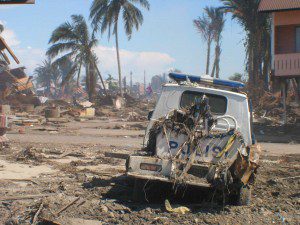Tsunami devastation - Police vehicle badly damaged sits in Meuloboh street (January, 2005).