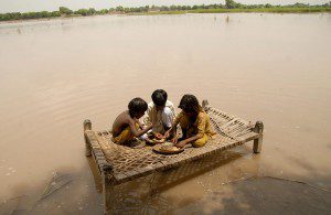 Displaced children play on a makeshift surface, after being displaced due to flood waters. 