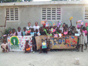 Children at an orphanage in Leogane hold a thank you banner they made for children at Donald Cousens Primary school in Markham