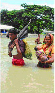 August 3, 2007: A couple with their baby moves to a safe place, wading through flood water. 