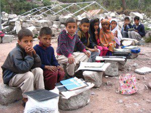 Children use the rubble of their collapsed school to study on. 