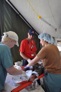 CMAT Surgeon Dr. Donna Smith, Anaesthesiologist Dr. Kate Bennett and Paramedic Bill Coltart prepare a patient for surgery in the CMAT field hospital in Léogâne.