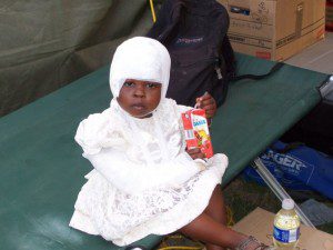 A little girl with a head injury and broken arm being treated at the CMAT Field Hospital in Leogane