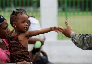 A young child reaches out to greet a soldier in Port au Prince, Haiti. 