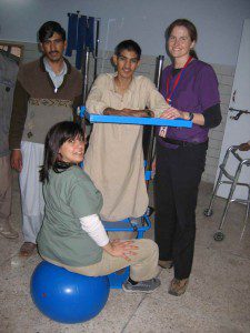 Joan & Sarah assisting E.J. (18 y/o from Bagh with incomplete spinal cord injury) as he stands (for the first time in 4 months) in standing frame. 