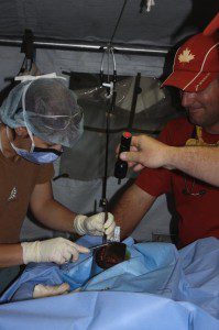 After disaster, infrastructure is unreliable, occasionally requiring surgery to be performed by flashlight at the CMAT field hospital.