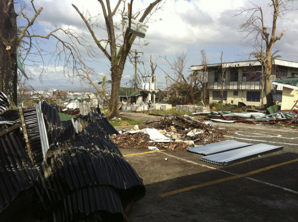 The wrath of Typhoon Yolanda (Haiyan) is evident on the buildings of Ormoc.  Roof sheets torn off by the wind are wrapped around trees. 