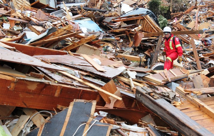 CMAT Volunteer Martin Metz climbs over hundreds of feet of debris in Ishinomaki, Japan - 2011. 